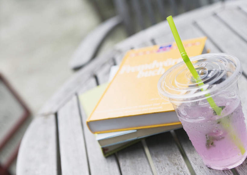 果汁,无人,横图,俯视,室外,特写,白天,桌面,桌子,杯子,书籍,椅子,朦胧,模糊,木制,塑料,木椅,饮品,饮料,一个,木制品,塑料制品,吸管,单个,塑料杯,空心,可口,咖啡店,咖啡屋,饮管,适口,书,图书,彩图,高角度拍摄,咖啡馆,圆柱状