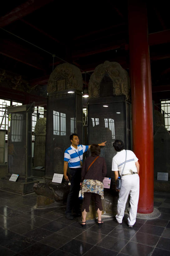 东方人,背部,三个人,导游,站,竖图,室内,白天,正面,旅游,度假,名胜古迹,标志建筑,地标,建筑,雕塑,西安,中国,亚洲,行人,游客,游人,指,服装,遗迹,艺术,装饰,雕刻,雕像,古典,注视,黄种人,方向,古迹,文化,文物,娱乐,标识,吊牌,建设,古建筑,石雕,石刻,路人,旅客,衣服,石碑,胸牌,工艺品,观察,看,手势,站着,享受,休闲,旅游胜地,放松,服饰,古董,观看,纪念,美术,察看,徽章,指向,衣着,食指,古物,穿着,关注,主题,身份,陈列,古玩,古文明,东亚,胸章,胸卡,陕西,陕西省,西安市,中华人民共和国,省会,功能,美学,编号牌,雕刻牌,工号牌,胸号牌,胸徽,员工牌,西北地区,陕,衣饰,过客,男人,男性,女人,女性,中年男性,中年女性,亚洲人,向导,站立,彩图,全身,打手势,指引者