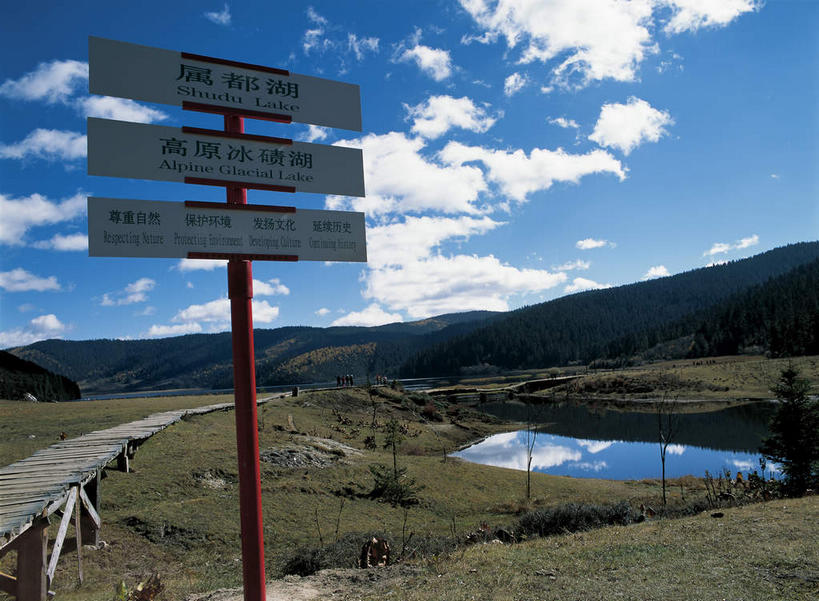 无人,公园,横图,室外,白天,正面,旅游,度假,草地,草坪,湖,湖泊,美景,山,山脉,水,植物,道路,路,指示牌,香格里拉,中国,亚洲,阴影,光线,标志,路标,影子,湖面,景观,山峰,水流,水面,云,云朵,小路,交通,山峦,云彩,娱乐,标识,路牌,迪庆,云南,草,树,树木,蓝色,绿色,白云,倒影,蓝天,天空,阳光,自然,湖水,群山,天,享受,休闲,景色,放松,生长,晴朗,成长,倒映,国家公园,自然风光,东亚,中甸,迪庆藏族自治州,云南省,中华人民共和国,西南地区,滇,迪庆州,反照,香格里拉县,普达措国家公园,晴空,彩图,属都岗湖,属都湖