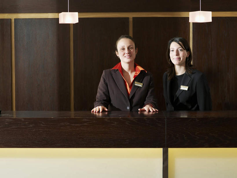 西方人,两个人,伙伴,朋友,前台,服务员,站,笑,微笑,横图,室内,白天,正面,工作服,制服,友谊,合作,团队,桌面,桌子,酒店,指示牌,欧洲,欧洲人,木制,标志,文字,墙,注视,标识,墙壁,墙面,木制品,观察,看,站着,战略,观看,察看,关注,联合,合谋,工作制服,接待员,配合,协作,年轻女性,女人,女性,白种人,服务生,侍者,站立,半身,彩图,工作套服,旅店