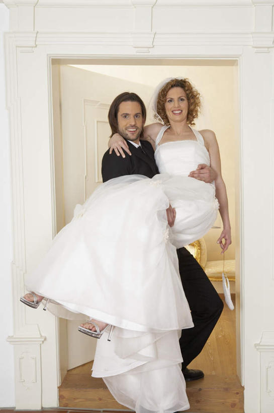 西方人,两个人,家庭,夫妻,新娘,新郎,站,笑,微笑,露齿笑,竖图,室内,白天,正面,婚纱,西装,爱情,婚礼,快乐,门,欧洲,欧洲人,套装,正装,庆祝,结婚,浪漫,注视,职业装,门框,观察,看,站着,温暖,温馨,喜庆,一家人,恩爱,恋人,观看,纪念,和睦,察看,关注,新娘抱,公主抱,男人,男性,年轻男性,女人,女性,中年女性,白种人,年轻人,夫妇,情侣,站立,彩图,全身,婚礼服,礼服,高兴,伴侣,融洽