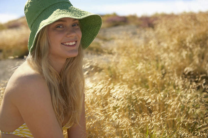 西方人,一个人,坐,笑,微笑,露齿笑,横图,室外,白天,侧面,泳装,比基尼,植物,帽子,欧洲,欧洲人,仅一个年轻女性,仅一个女性,仅一个人,阴影,枯萎,朦胧,模糊,光线,影子,枯草,扭头,注视,草,黄色,蓝色,绿色,蓝天,天空,阳光,遮阳帽,天,观察,看,转头,晴朗,观看,渔夫帽,察看,关注,万里无云,年轻女性,女人,女性,白种人,晴空,晴空万里,坐着,半身,彩图,三点式,泳衣