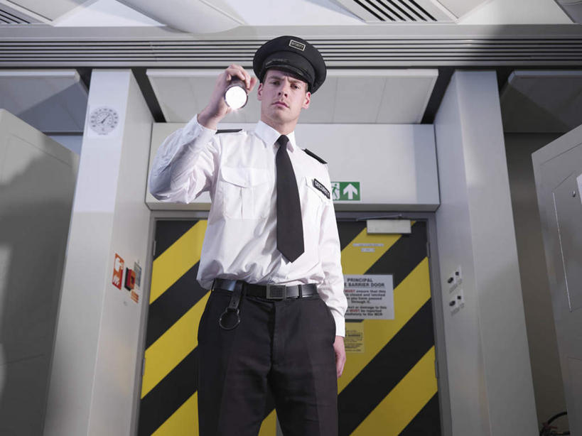 西方人,一个人,警察,警卫,站,横图,室内,白天,仰视,工作服,制服,门,帽子,照明,欧洲,欧洲人,仅一个男性,仅一个人,握,灯光,领带,拿,拿着,注视,灯,仅一个年轻男性,门框,观察,看,站着,握着,军帽,观看,照亮,察看,象征,庄重,照明设备,关注,身份,手电筒,电筒,手电,正式,地位,工作制服,男人,男性,年轻男性,白种人,保安,警卫员,看守,卫兵,站立,半身,彩图,低角度拍摄,工作套服