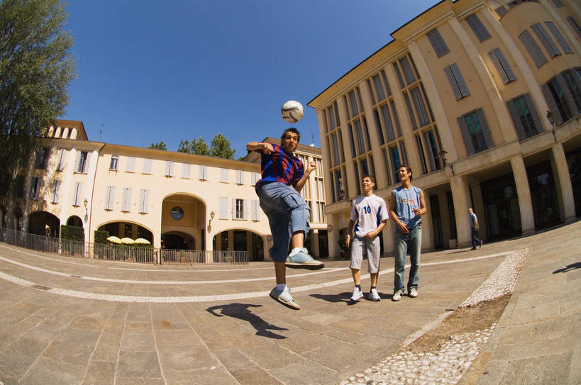 西方人,三个人,运动员,站,跳,笑,微笑,露齿笑,横图,室外,白天,正面,广角镜头,鱼眼镜头,运动服,足球,植物,建筑,欧洲,欧洲人,阴影,服装,光线,颠球,影子,足球装备,半空,注视,运动器械,树,树木,衣服,蓝色,绿色,蓝天,天空,阳光,自然,天,观察,看,站着,健身器械,服饰,生长,成长,观看,察看,衣着,穿着,关注,健身器材,修建,蹴鞠,修筑,衣饰,足球运动,男人,男性,年轻男性,白种人,体育运动员,运动选手,抬头,跳跃,仰头,站立,彩图,全身,运动器材,运动装