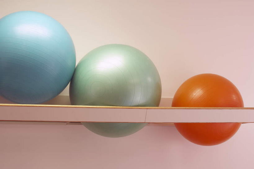 无人,横图,室内,特写,白天,正面,静物,金属制品,一排,整齐,金属,墙,架子,墙壁,墙面,排列,三个,蓝色,绿色,橙色,健身球,瑜伽球,队列,彩图
