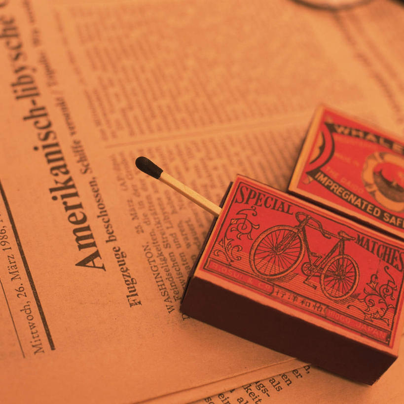 无人,方图,俯视,室内,特写,白天,桌面,桌子,静物,报纸,火,信息,英文,火柴,燃烧,火柴盒,温暖,激情,英文字母,新闻,彩图,高角度拍摄