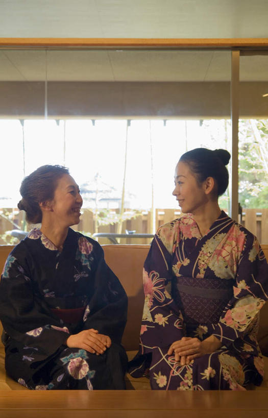 头发,两个人,伙伴,朋友,客厅,坐,笑,微笑,露齿笑,竖图,室内,白天,正面,民族服装,友谊,植物,餐桌,窗户,落地窗,沙发,桌子,阴影,花纹,和服,光线,图案,影子,墙,扭头,注视,玻璃窗,相视,墙壁,墙面,树,树木,绿色,黑色,阳光,自然,观察,看,靠,靠着,倚靠,转头,面对面,服饰,生长,成长,餐台,观看,对视,察看,起居室,倚着,关注,相对,布艺沙发,吴服,相看,唐草,唐花,唐锦,友情,年轻女性,女人,女性,坐着,半身,彩图,传统服装,民俗服