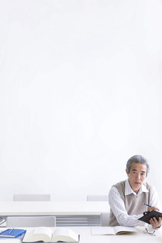 东方人,一个人,坐,竖图,室内,白天,正面,桌子,亚洲,仅一个男性,仅一个人,笔,墙,办公用品,圆珠笔,拿,拿着,黄种人,书桌,墙壁,墙面,文具,课桌,学习用品,仅一个老年男性,文具用品,老年男性,男人,男性,亚洲人,坐着,半身,彩图