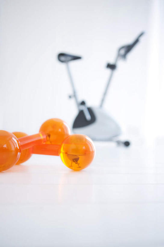 无人,竖图,俯视,室内,特写,白天,地板,自行车,哑铃,朦胧,模糊,地面,运动器械,木地板,脚踏车,两个,三个,橙色,健身器械,健身器材,动感单车,动感自行车,彩图,高角度拍摄,运动器材