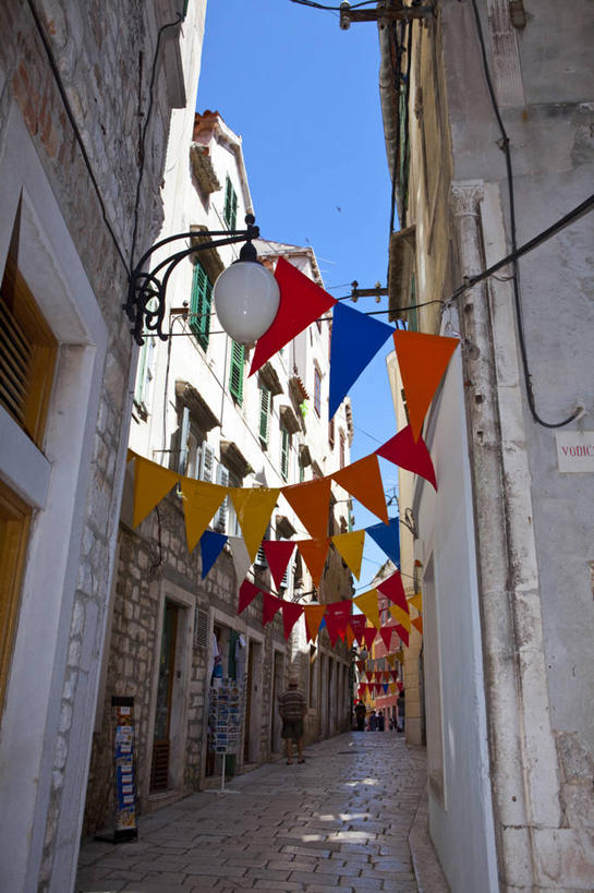 西方人,家,站,走,竖图,彩色,室外,白天,仰视,度假,美景,城市风光,城市,道路,路,旗帜,欧洲,克罗地亚,欧洲人,一排,许多,行人,阴影,服装,整齐,光线,影子,房屋,屋子,景观,小路,交通,很多,许多人,注视,休闲装,娱乐,旗子,楼房,路人,住宅,排列,衣服,蓝色,蓝天,天空,阳光,天,观察,看,站着,一群人,享受,休闲,休闲服,景色,放松,服饰,晴朗,观看,五颜六色,色彩斑斓,察看,队列,关注,五彩缤纷,万里无云,五彩斑斓,旌旗,旗号,克罗地亚共和国,五光十色,达尔马提亚,过客,达尔马提亚群岛,男人,男性,年轻男性,年轻女性,女人,女性,白种人,晴空,晴空万里,步行,散步,站立,走路,半身,彩图,低角度拍摄,房子,希贝尼克.克宁县