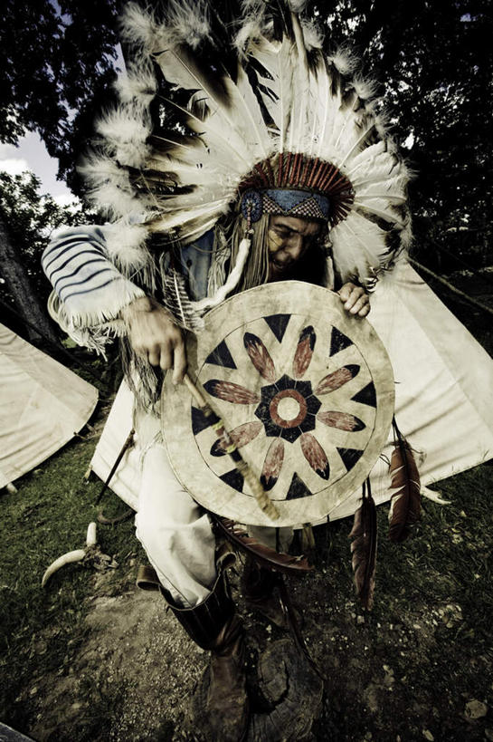 西方人,一个人,家,竖图,室外,白天,正面,民族服装,羽毛,金属制品,欧洲,欧洲人,仅一个男性,仅一个人,仅一个中年男性,握,轻盈,柔软,金属,帐篷,房屋,屋子,拿,拿着,注视,文化,传统,住宅,一个,蓝色,蓝天,天空,天,低头,观察,看,握着,盾牌,晴朗,单个,观看,察看,头冠,关注,万里无云,轻柔,印第安人帐篷,印第安帐篷,男人,男性,中年男性,白种人,晴空,晴空万里,半身,彩图,传统服装,民俗服,房子,小屋