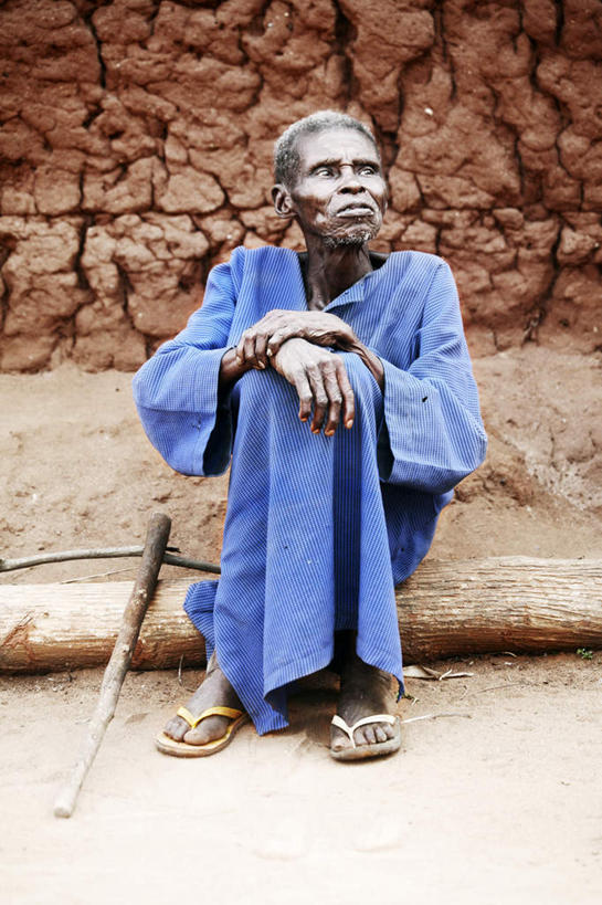 西方人,一个人,坐,竖图,室外,白天,正面,凉鞋,石头,鞋子,欧洲,非洲,贝宁,黑人,欧洲人,仅一个男性,仅一个人,阴影,服装,光线,石子,影子,墙,树桩,注视,休闲装,墙壁,墙面,树,树干,衣服,阳光,观察,看,仅一个老年男性,休闲,休闲服,木桩,搭,服饰,观看,察看,搭着,关注,阿非利加洲,贝宁共和国,老年男性,男人,男性,非洲人,石块,抬头,仰头,坐着,彩图,全身,夹趾拖鞋,人字拖,人字拖鞋
