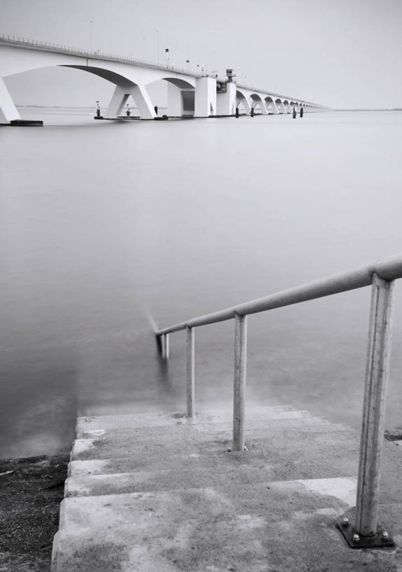 无人,栏杆,竖图,黑白,室外,白天,仰视,旅游,度假,海浪,海洋,石头,楼梯,标志建筑,地标,建筑,欧洲,荷兰,阴影,光线,扶手,石子,影子,阶梯,浪花,水平线,云,云朵,桥,辽阔,海平线,云彩,娱乐,建设,石桥,护栏,台阶,栈桥,蓝色,白云,蓝天,天空,阳光,海水,天,享受,休闲,广阔,旅游胜地,放松,晴朗,人行桥,一望无际,西欧,海景,荷兰王国,尼德兰王国,无边无际,一马平川,泽兰省,大海,风浪,海,海水的波动,近岸浪,石块,涌浪,晴空,低角度拍摄,水天相接,水天一线