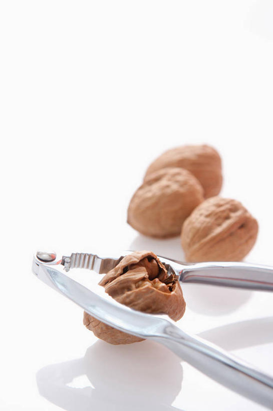 无人,竖图,俯视,室内,特写,白天,白色背景,餐桌,桌子,阴影,朦胧,模糊,反射,工具,钳子,影子,核桃,坚果,果实,一个,白色,干果,四个,摄影,影棚,单个,餐台,五金,胡桃,核桃钳,胡桃钳,羌桃,胡桃夹,彩图,高角度拍摄,影棚拍摄,拍摄