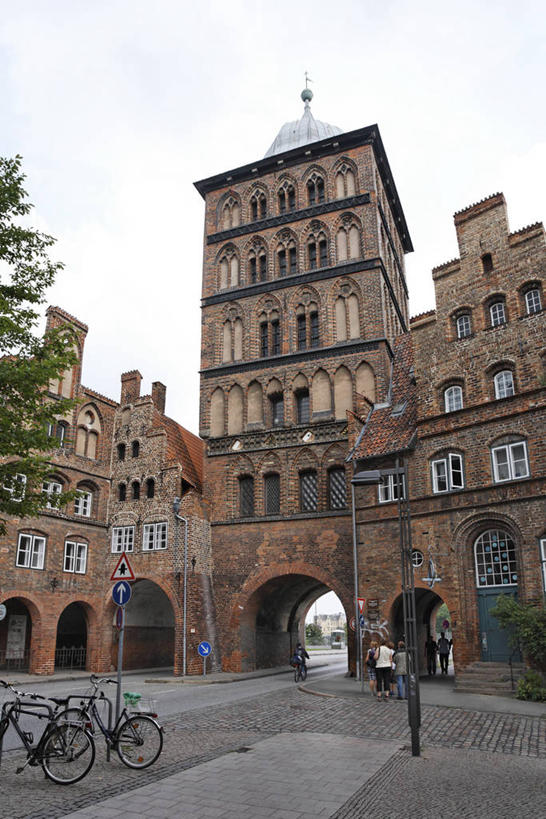 无人,竖图,室外,白天,仰视,旅游,度假,植物,标志建筑,地标,建筑,路灯,自行车,照明,德国,欧洲,阴影,光线,影子,灯光,娱乐,建设,车,脚踏车,灯,树,树木,蓝色,绿色,蓝天,天空,阳光,自然,交通工具,天,享受,休闲,旅游胜地,放松,生长,晴朗,成长,照亮,照明设备,西欧,载具,万里无云,德意志联邦共和国,石荷州,石勒苏益格.荷尔斯泰因,石勒苏益格.荷尔斯泰因州,吕贝克,晴空,晴空万里,彩图,低角度拍摄,城堡门