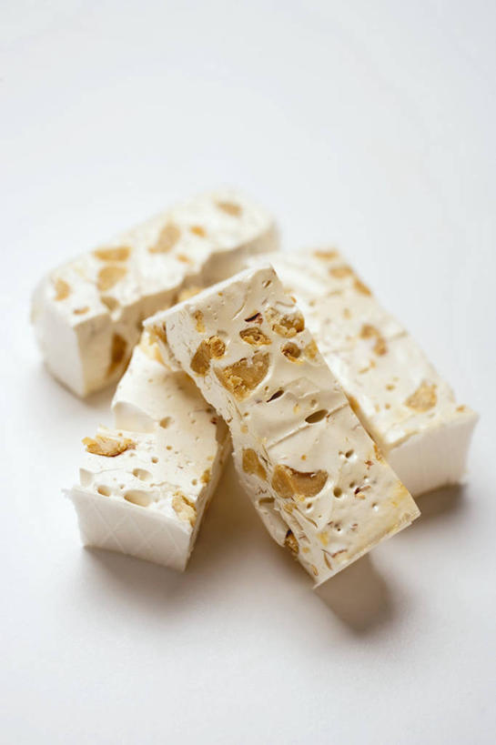 无人,竖图,俯视,室内,特写,白天,白色背景,餐桌,桌子,杏仁,一堆,阴影,堆叠,堆积,反射,影子,食品,糖,糖果,甜点,甜品,食物,甜食,摄影,影棚,餐台,堆,牛轧糖,鸟结糖,纽结糖,杏子,杏梅仁,杏核仁,木落子,苦杏仁,彩图,高角度拍摄,影棚拍摄,拍摄