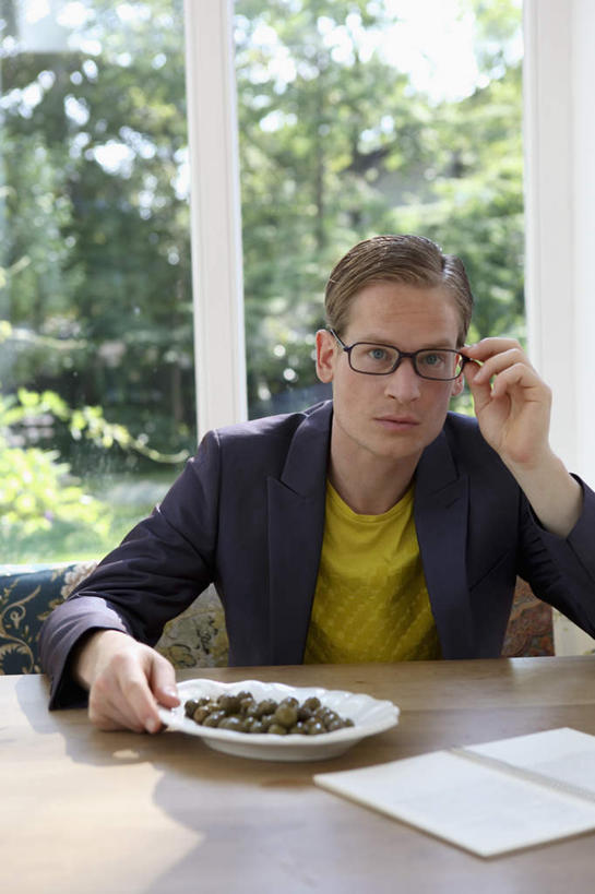 西方人,一个人,坐,竖图,室内,白天,正面,植物,窗户,桌面,桌子,橄榄,餐具,书籍,水果,欧洲,欧洲人,仅一个男性,仅一个人,仅一个中年男性,一堆,一副,许多,握,堆叠,堆积,服装,朦胧,模糊,新鲜,木制,碟子,盘,眼镜,生食,食品,果实,很多,拿,拿着,注视,休闲装,玻璃窗,树,树木,食物,衣服,绿色,自然,盘子,木制品,碟,观察,看,休闲,休闲服,握着,服饰,有机食品,绿色食品,生长,成长,观看,堆,察看,关注,近视眼镜,男人,男性,中年男性,白种人,书,图书,青果,白榄,坐着,半身,彩图