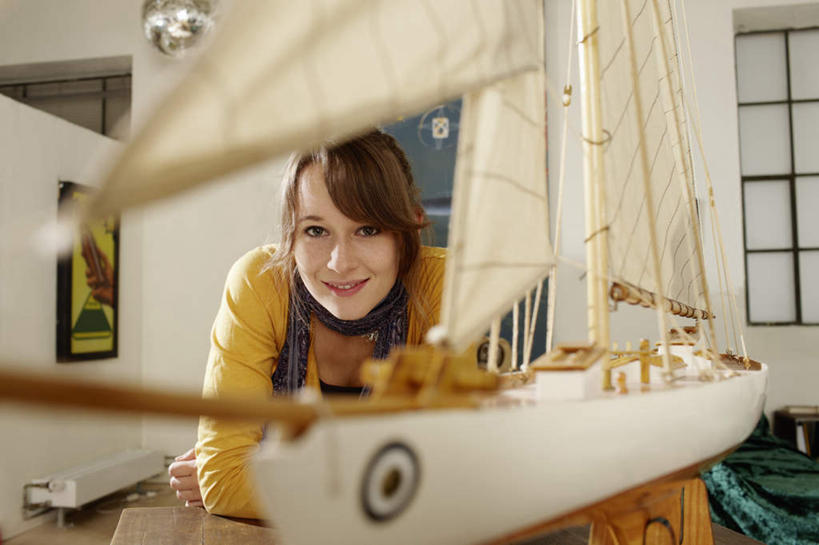帆船,西方人,一个人,站,笑,微笑,露齿笑,横图,室内,白天,正面,窗户,桌面,桌子,船,欧洲,欧洲人,仅一个年轻女性,仅一个女性,仅一个人,一条,撑,服装,朦胧,模糊,装饰,立体,空间,木制,墙,注视,休闲装,玻璃窗,墙壁,墙面,衣服,模型,木制品,围巾,黑板,交通工具,观察,看,站着,休闲,温暖,休闲服,规划,教学,服饰,围脖,观看,保暖,华丽,点缀,察看,撑着,御寒,关注,载具,衬托,美观,雅致,雅观,直观,建筑模型,建筑设计,耐磨,教学黑板,年轻女性,女人,女性,白种人,设计,站立,半身,彩图
