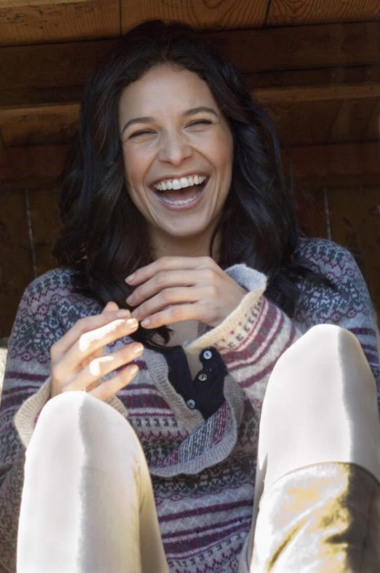 西方人,一个人,坐,笑,微笑,露齿笑,竖图,室外,白天,正面,欧洲,欧洲人,仅一个年轻女性,仅一个女性,仅一个人,服装,墙,棕色,注视,休闲装,墙壁,墙面,衣服,观察,看,休闲,休闲服,服饰,观看,察看,关注,年轻女性,女人,女性,白种人,长发,卷发,屈膝,坐着,半身,彩图