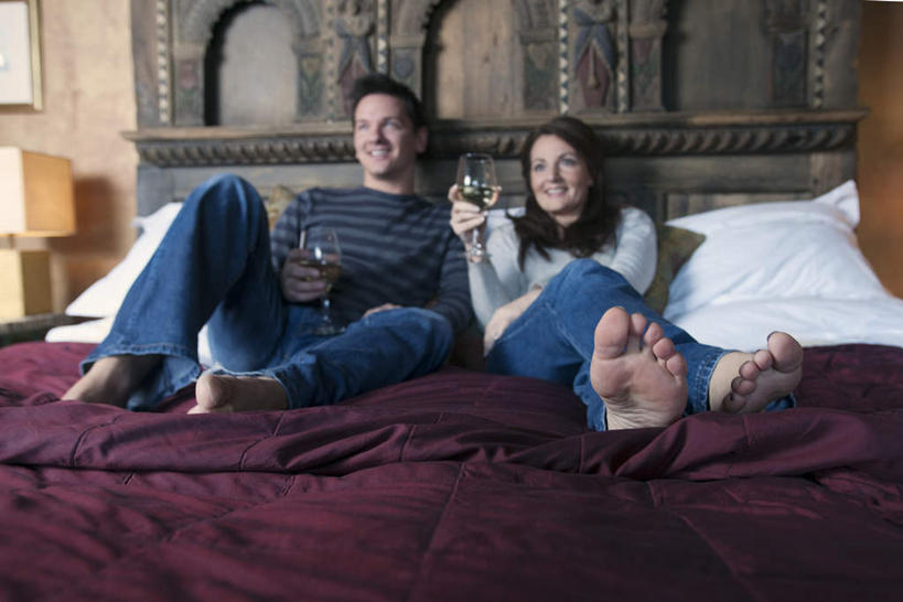 红酒,葡萄酒,西方人,两个人,夫妻,躺,笑,微笑,露齿笑,横图,室内,白天,正面,爱情,床,靠垫,卧室,杯子,欧洲,欧洲人,握,服装,高脚杯,墙,双人床,床单,靠枕,红酒杯,白葡萄酒,酒类,浪漫,拿,拿着,注视,休闲装,光脚,被子,墙壁,墙面,玻璃制品,酒,饮料,衣服,紫色,酒杯,垫子,枕头,观察,看,靠,靠着,休闲,赤脚,休闲服,恩爱,握着,恋人,服饰,观看,察看,被单,葡萄酒杯,关注,卧着,男人,男性,年轻男性,女人,女性,中年女性,白种人,夫妇,情侣,玻璃杯,躺着,卧,彩图,全身,睡房,卧房,伴侣