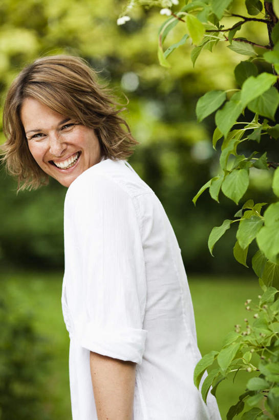 西方人,一个人,站,笑,微笑,露齿笑,竖图,室外,白天,侧面,草地,草坪,植物,欧洲,欧洲人,仅一个女性,仅一个人,服装,朦胧,模糊,棕色,扭头,注视,休闲装,草,树,树木,衣服,绿色,白色,自然,观察,看,站着,转头,仅一个中年女性,休闲,休闲服,服饰,生长,成长,观看,察看,关注,女人,女性,中年女性,白种人,卷发,站立,半身,彩图