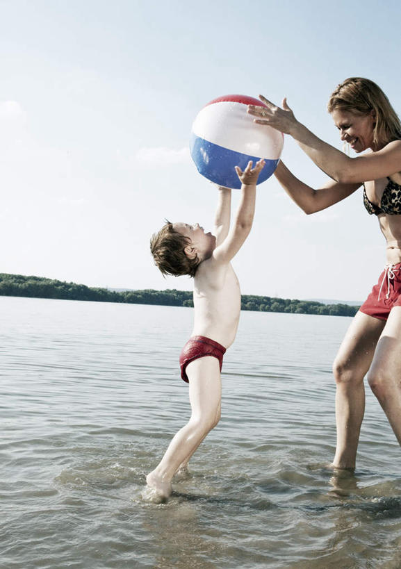 西方人,儿童,中年人,两个人,家庭,母亲,儿子,站,举,笑,微笑,露齿笑,竖图,室外,白天,侧面,泳装,比基尼,游戏,纯洁,河流,山,山脉,水,植物,玩具,欧洲,欧洲人,弯腰,握,阴影,光线,影子,塑料,河水,山峰,水流,云,云朵,山峦,拿,玩,云彩,拿着,注视,娱乐,裸露,树,树木,一个,小孩,蓝色,绿色,白云,蓝天,天空,阳光,自然,气球,塑料制品,群山,天,观察,看,托,站着,休闲,温暖,温馨,母子,一家人,充气玩具,橡胶,可爱,母爱,童年,童趣,益智,握着,生长,晴朗,单个,成长,观看,张开双腿,活动,和睦,察看,发泄,关注,消遣,智力,裸,童真,橡胶制品,烂漫,无邪,宣泄,弯身,展开双腿,天真,男孩,女人,女性,中年女性,白种人,孩子,晴空,举起,举手,举着,抬头,玩耍,嬉戏,向上举,向上伸,向上托,仰头,站立,半身,彩图,三点式,泳衣,融洽,男生,伸展双腿