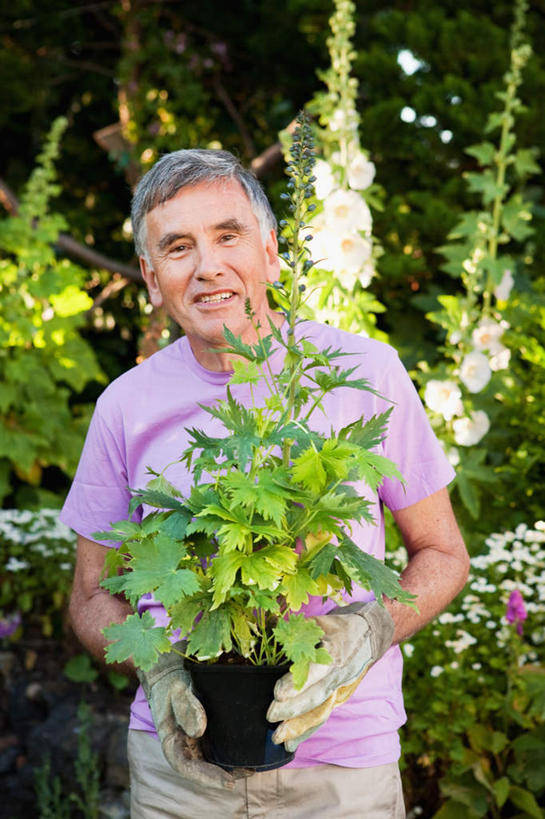 西方人,一个人,站,捧,笑,微笑,露齿笑,竖图,室外,白天,正面,安全,草地,草坪,植物,欧洲,欧洲人,仅一个男性,仅一个人,仅一个中年男性,阴影,服装,朦胧,模糊,光线,盆栽,影子,防护,盆景,注视,休闲装,草,树,树木,衣服,绿色,阳光,自然,手套,观察,看,站着,休闲,休闲服,服饰,生长,成长,观看,保护,察看,关注,保险,保全,周全,安稳,安定,防护手套,平安,男人,男性,中年男性,白种人,端,端着,捧着,手捧,站立,半身,彩图