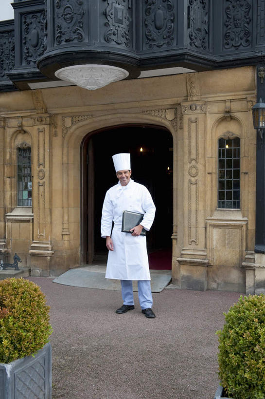 西方人,一个人,厨师,宾馆,站,笑,微笑,竖图,室外,白天,正面,工作服,制服,植物,窗户,门,酒店,帽子,欧洲,欧洲人,仅一个男性,仅一个人,仅一个中年男性,盆栽,墙,盆景,地面,拿,拿着,注视,玻璃窗,墙壁,墙面,菜单,绿色,白色,自然,门框,观察,看,站着,生长,成长,观看,察看,关注,厨师帽,工作制服,男人,男性,中年男性,白种人,厨师长,厨子,大厨,主厨,站立,彩图,全身,工作套服,客店,客栈,旅店,旅馆,旅舍,汽车旅馆