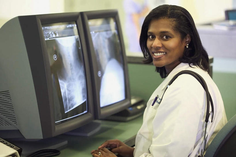西方人,一个人,医生,办公室,坐,笑,微笑,露齿笑,横图,x光片,室内,白天,侧面,工作服,制服,职员,电脑,桌子,欧洲,非洲,黑人,欧洲人,双手,仅一个年轻女性,仅一个女性,仅一个人,朦胧,模糊,扭头,注视,显示屏,听诊器,观察,看,转头,台式电脑,观看,两台,察看,放置,关注,光片,工作制服,年轻女性,女人,女性,非洲人,脸部,医师,坐着,半身,彩图,工作套服