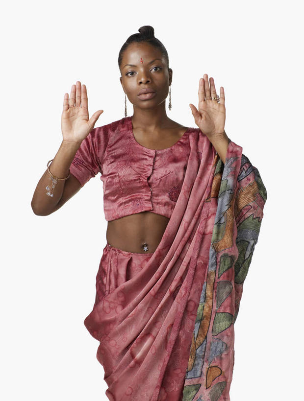 西方人,一个人,站,举,竖图,室内,白天,白色背景,正面,民族服装,项链,欧洲,非洲,黑人,欧洲人,仅一个女性,仅一个人,注视,裸露,装饰品,耳环,饰品,首饰,观察,看,托,站着,仅一个中年女性,脐环,摄影,服饰,影棚,观看,飘逸,察看,庄重,关注,裸,追求,纱丽,雅致,耳饰,纱丽服,清婉,妍丽,肚脐环,女人,女性,中年女性,非洲人,举起,举手,举着,向上举,向上伸,向上托,站立,半身,彩图,影棚拍摄,传统服装,民俗服,拍摄,奢华