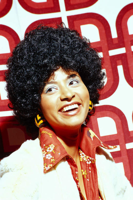 西方人,一个人,站,笑,微笑,露齿笑,竖图,室内,白天,正面,欧洲,非洲,黑人,欧洲人,仅一个年轻女性,仅一个女性,仅一个人,花纹,服装,方格,格子,图案,墙,注视,休闲装,墙壁,墙面,装饰品,衣服,红色,耳环,饰品,首饰,观察,看,站着,休闲,休闲服,摄影,服饰,影棚,观看,察看,关注,爆炸头,耳饰,年轻女性,女人,女性,非洲人,站立,半身,彩图,影棚拍摄,拍摄