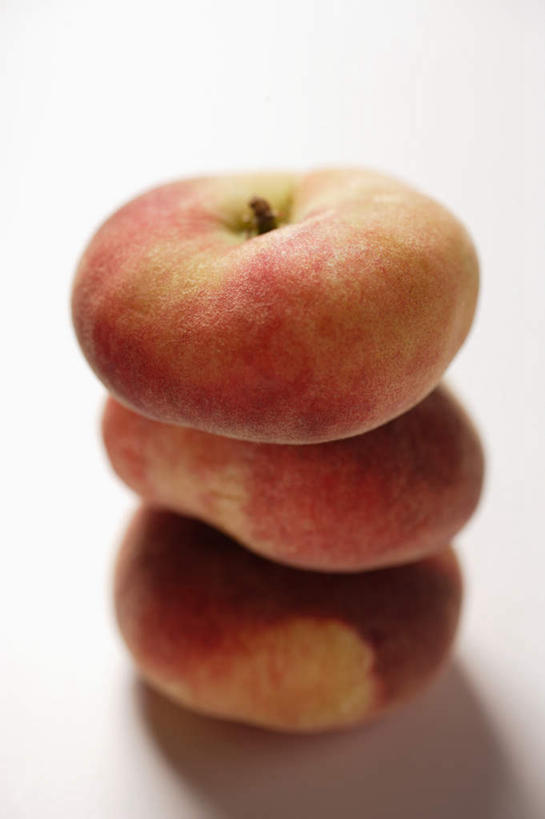 无人,竖图,俯视,室内,特写,白天,白色背景,餐桌,桌子,桃子,水果,一排,阴影,新鲜,整齐,反射,影子,生食,食品,果实,食物,排列,三个,红色,水蜜桃,摄影,有机食品,绿色食品,影棚,餐台,堆,队列,蟠桃,肺果,彩图,高角度拍摄,影棚拍摄,拍摄