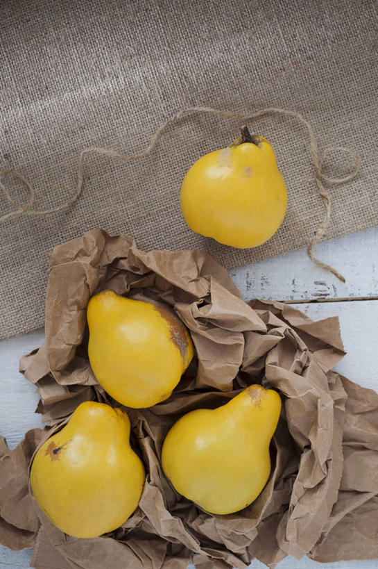 无人,竖图,俯视,室内,特写,白天,桌面,桌子,袋子,水果,阴影,新鲜,反射,木制,影子,生食,食品,果实,麻袋,食物,一个,黄色,木制品,容器,四个,有机食品,绿色食品,单个,储藏,储存,榅桲,木梨,彩图,高角度拍摄,比也,金苹果,蛮檀,楔楂,贮存