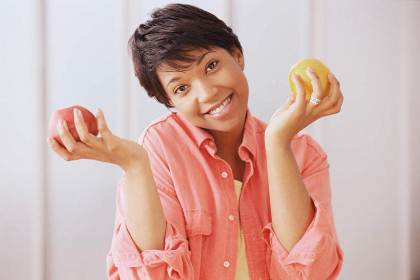 西方人,一个人,站,笑,微笑,露齿笑,横图,室内,白天,正面,苹果,水果,欧洲,非洲,黑人,欧洲人,仅一个女性,仅一个人,握,服装,新鲜,生食,食品,果实,拿,拿着,注视,休闲装,食物,衣服,观察,看,站着,仅一个中年女性,休闲,休闲服,耸肩,握着,服饰,有机食品,绿色食品,观看,察看,关注,女人,女性,中年女性,非洲人,站立,半身,彩图