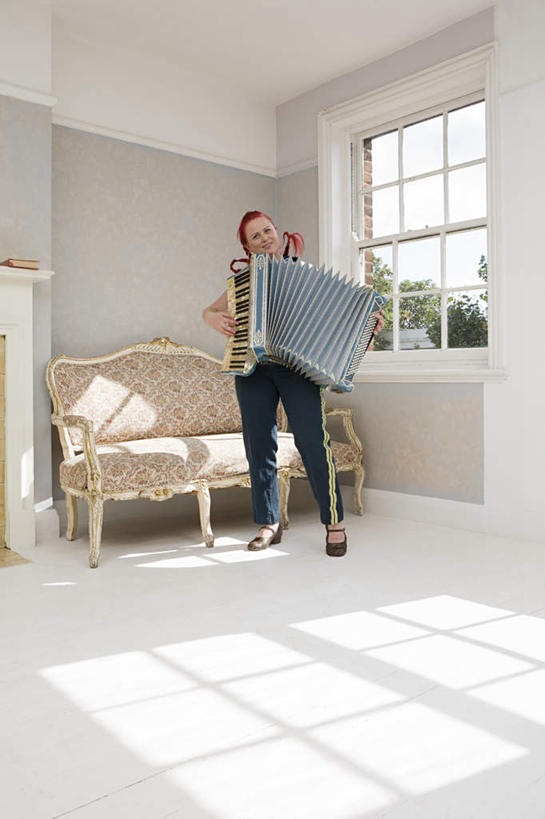 西方人,一个人,客厅,站,竖图,室内,白天,正面,键盘,植物,窗户,沙发,欧洲,欧洲人,仅一个女性,仅一个人,握,阴影,服装,反射,影子,墙,手风琴,弹奏,拿,拿着,注视,管风琴,玻璃窗,墙壁,墙面,树,树木,衣服,绿色,自然,观察,看,站着,仅一个中年女性,握着,服饰,生长,成长,观看,察看,起居室,键盘乐器,衣着,穿着,关注,布艺沙发,衣饰,客堂,女人,女性,中年女性,白种人,站立,彩图,全身