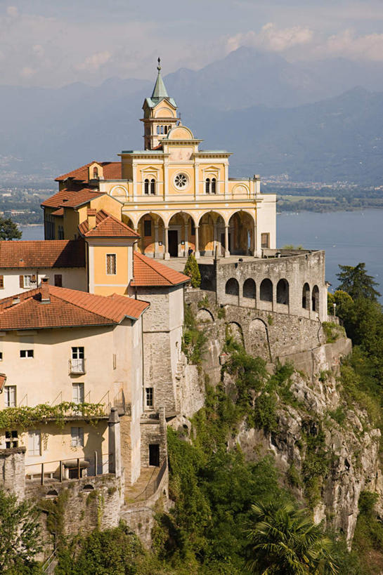 无人,寺庙,竖图,室外,白天,正面,旅游,度假,湖,湖泊,名胜古迹,山,山脉,水,植物,标志建筑,地标,建筑,瑞士,欧洲,阴影,节日,遗迹,光线,影子,湖面,山峰,水流,水面,云,云朵,拱门,山峦,燃烧,云彩,古迹,文化,文物,娱乐,建设,古建筑,树,树木,蓝色,绿色,白云,蓝天,天空,阳光,自然,香火,庙宇,湖水,群山,天,祈祷,享受,休闲,健康,旅游胜地,放松,许愿,宗教,信仰,生长,晴朗,成长,纪念,祈求,古文明,中欧,瑞士联邦,提契诺州,洛迦诺,平安,晴空,彩图,庙,寺