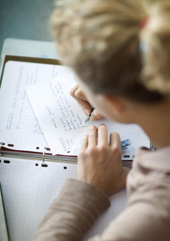 西方人,一个人,坐,竖图,俯视,室内,白天,桌面,桌子,欧洲,欧洲人,仅一个年轻女性,仅一个女性,仅一个人,笔,记事本,拿,拿着,注视,本子,笔记本,观察,看,作业,观看,察看,关注,年轻女性,女人,女性,白种人,坐着,半身,彩图,高角度拍摄