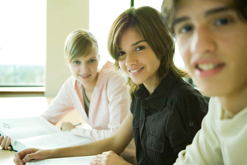 西方人,三个人,图书馆,坐,笑,微笑,露齿笑,横图,室内,白天,正面,桌子,书籍,欧洲,欧洲人,书桌,课桌,浏览室,男人,男性,年轻男性,年轻女性,女人,女性,白种人,书,图书,坐着,半身,彩图,书库,图书库,阅览室