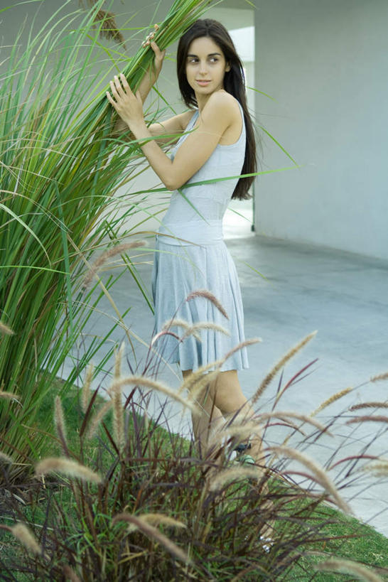 西方人,一个人,站,笑,微笑,露齿笑,竖图,室外,白天,正面,草地,草坪,植物,芦苇,叶子,欧洲,欧洲人,仅一个年轻女性,仅一个女性,仅一个人,阴影,服装,光线,瓷砖,地砖,影子,墙,粽叶,绿叶,地面,注视,休闲装,狗尾巴草,墙壁,墙面,草,衣服,绿色,阳光,观察,看,站着,休闲,休闲服,抓,嫩叶,服饰,观看,察看,关注,箬叶,芦苇叶,年轻女性,女人,女性,白种人,叶,叶片,站立,彩图,全身