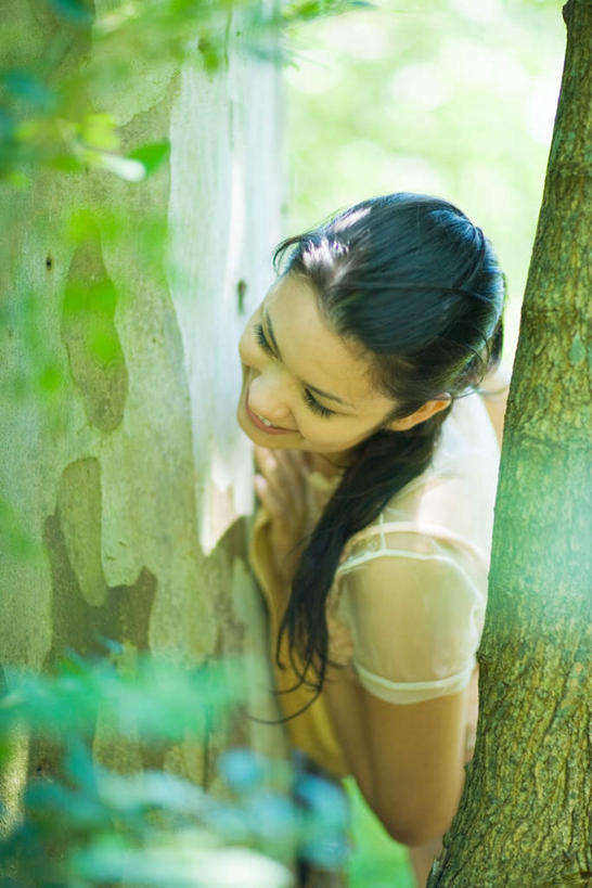 西方人,一个人,站,笑,微笑,露齿笑,竖图,俯视,室外,白天,植物,欧洲,欧洲人,仅一个年轻女性,仅一个女性,仅一个人,躲藏,阴影,朦胧,模糊,光线,影子,注视,休闲装,树,树木,绿色,阳光,自然,观察,看,倚靠,站着,休闲,休闲服,生长,成长,观看,察看,关注,年轻女性,女人,女性,白种人,站立,半身,彩图,高角度拍摄