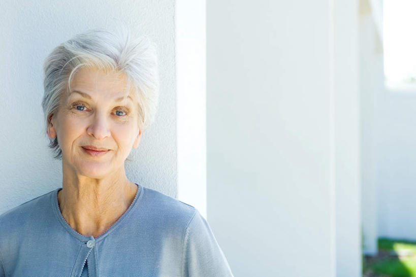 西方人,一个人,笑,微笑,露齿笑,横图,室外,白天,正面,草地,草坪,植物,欧洲,欧洲人,仅一个女性,仅一个人,阴影,光线,影子,墙,依靠,墙壁,墙面,草,绿色,白色,阳光,靠,靠着,倚靠,仅一个老年女性,老年女性,女人,女性,白种人,半身,彩图