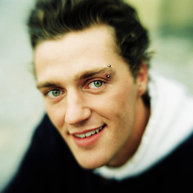 西方人,脸,头,脸颊,一个人,坐,笑,微笑,露齿笑,方图,室内,特写,白天,正面,欧洲,欧洲人,仅一个男性,仅一个人,服装,朦胧,模糊,注视,休闲装,肩膀,装饰品,仅一个年轻男性,衣服,饰品,首饰,观察,看,休闲,休闲服,服饰,观看,察看,关注,眉钉,男人,男性,年轻男性,白种人,头部,脸部,脸蛋,面部,抬头,仰头,坐着,半身,彩图