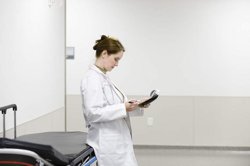 西方人,一个人,医生,医院,站,横图,室内,白天,侧面,欧洲,欧洲人,仅一个年轻女性,仅一个女性,仅一个人,笔,墙,办公用品,记事本,注视,墙壁,墙面,文具,本子,笔记本,病床,学习用品,低头,观察,看,靠,靠着,倚靠,站着,医护人员,医疗人员,观看,文具用品,察看,倚着,关注,急救床,医疗机构,文化工具,年轻女性,女人,女性,白种人,大夫,站立,半身,彩图,病院,诊所