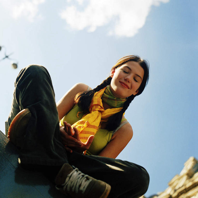 西方人,一个人,坐,盘腿,方图,室外,白天,仰视,欧洲,欧洲人,仅一个年轻女性,仅一个女性,仅一个人,云,云朵,云彩,蓝色,白云,蓝天,天空,天,年轻女性,女人,女性,白种人,盘腿而坐,盘膝,盘着腿的,盘着腿坐,双腿交叉,坐着,彩图,低角度拍摄,全身