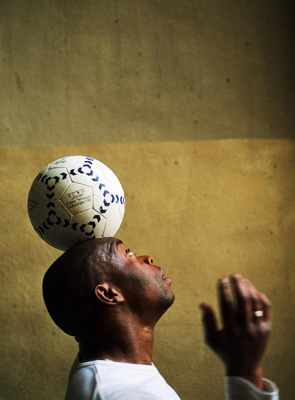 西方人,一个人,站,竖图,室外,白天,侧面,锻炼,运动,足球,欧洲,非洲,黑人,欧洲人,仅一个男性,仅一个人,阴影,光线,影子,墙,足球装备,顶,注视,运动器械,墙壁,墙面,仅一个年轻男性,阳光,看,站着,健身器械,关注,室外运动,健身器材,户外运动,蹴鞠,足球运动,男人,男性,年轻男性,非洲人,抬头,仰头,站立,半身,彩图,健身,运动器材