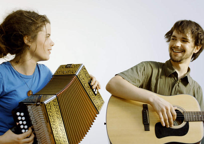 西方人,两个人,坐,笑,微笑,露齿笑,横图,室外,白天,正面,键盘,欧洲,欧洲人,服装,吉他,乐器,手风琴,弦乐器,注视,休闲装,管风琴,相视,衣服,观察,看,休闲,面对面,休闲服,服饰,观看,对视,察看,键盘乐器,关注,弹拨弦鸣乐器,相对,相看,男人,男性,年轻男性,年轻女性,女人,女性,白种人,坐着,半身,彩图,弹拨弦乐器