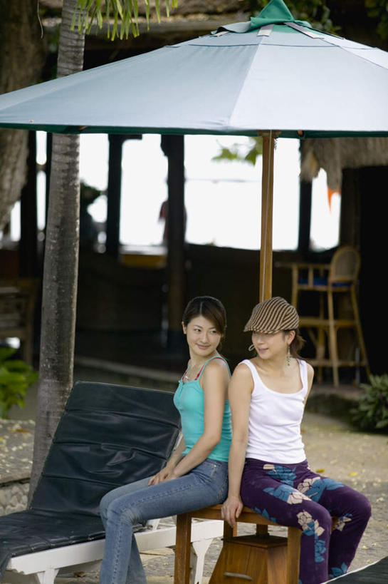 东方人,两个人,伙伴,朋友,坐,笑,微笑,露齿笑,竖图,室外,白天,正面,友谊,安全,桌子,帽子,亚洲,戴,房屋,躺椅,依靠,黄种人,倚靠,背靠背,背对背,沙滩椅,沙滩伞,信任,友情,年轻女性,女人,女性,亚洲人,坐着,半身,彩图