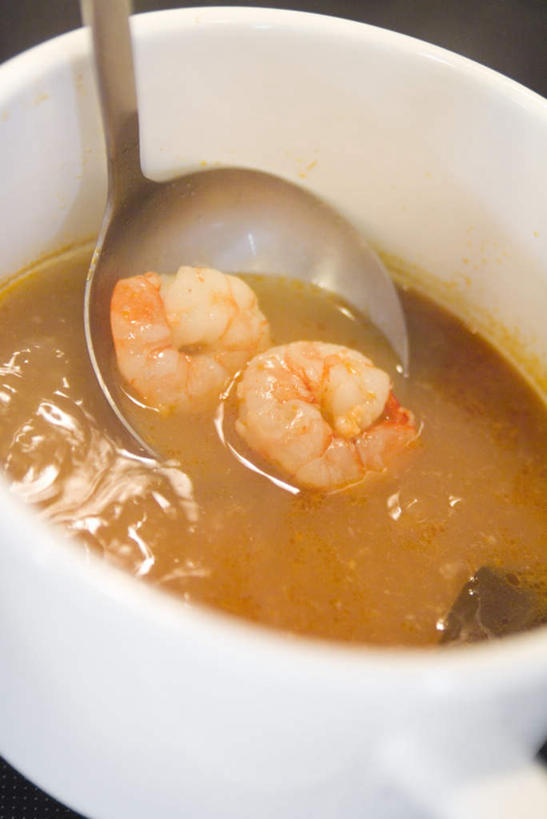 海鲜,无人,竖图,俯视,室内,特写,白天,餐桌,桌子,玻璃,勺子,汤,虾仁,陶瓷制品,水产,玻璃制品,一个,容器,调羹,汤匙,碗,单个,餐台,储藏,储存,海产品,泰式酸辣虾汤,彩图,高角度拍摄,贮存