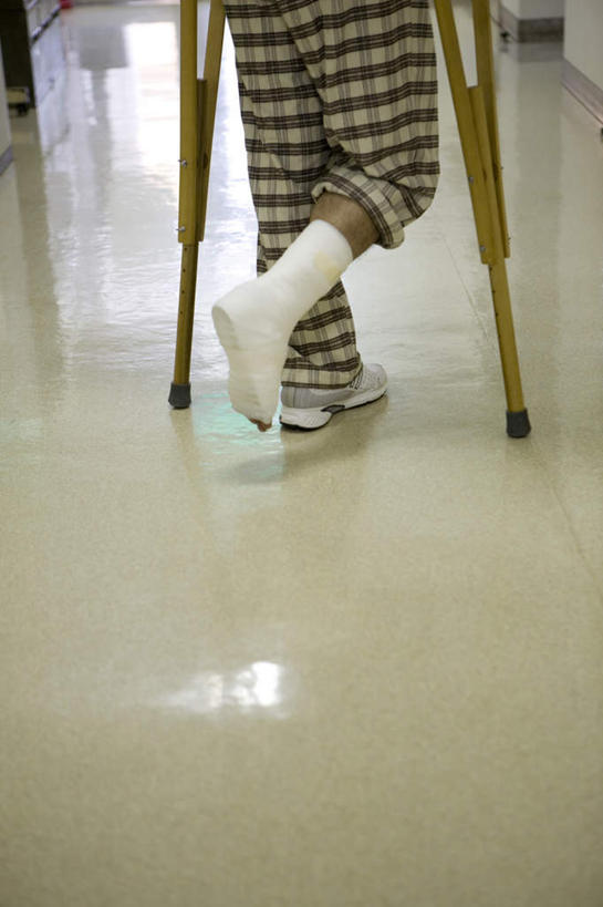 一个人,病人,竖图,俯视,室内,白天,地板,石膏,仅一个男性,仅一个人,阴影,服装,光线,工具,影子,地面,木地板,仅一个年轻男性,背面,器械,拐杖,病服,医疗器械,辅助设备,前臂拐,男人,男性,年轻男性,患者,就医者,创可贴,熟石膏,半身,彩图,高角度拍摄,护创胶布