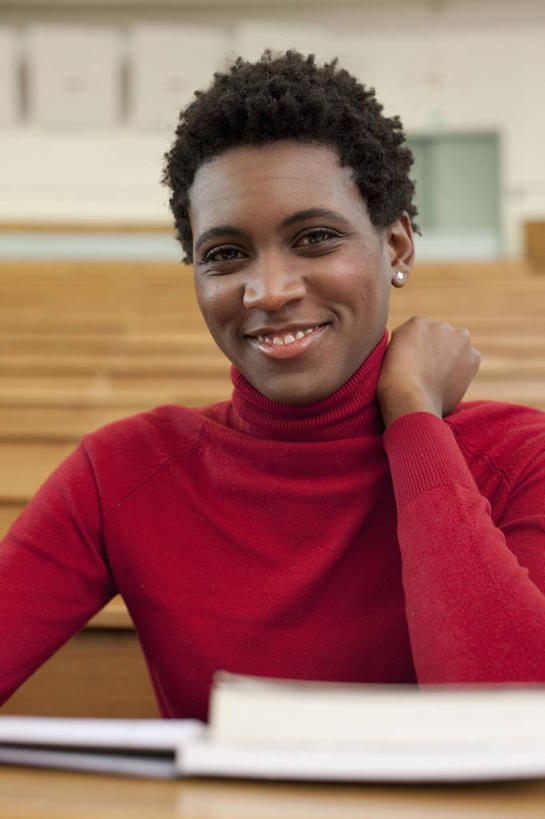 西方人,一个人,学校,教学楼,坐,笑,微笑,露齿笑,竖图,室内,白天,正面,毛衣,桌子,欧洲,非洲,黑人,欧洲人,仅一个年轻女性,仅一个女性,仅一个人,木制,墙,记事本,注视,书桌,校园,墙壁,墙面,装饰品,红色,本子,笔记本,耳环,课桌,木制品,饰品,首饰,观察,看,教室,搭,观看,察看,搭着,关注,线衫,耳饰,毛线衣,绒线衣,年轻女性,女人,女性,非洲人,坐着,半身,彩图,绒衣,套衫,套头毛衣,线衣,教学大楼,报告厅